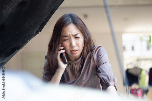asia woman upset and angry calling from mobile phone to mechanic after car broken 