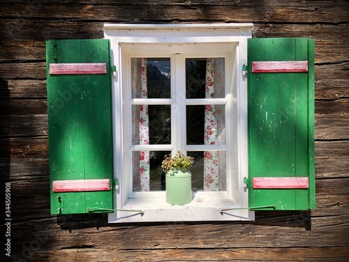 Typische grüne Fensterläden an traditionellem österreichischem alpinen alten Holzhaus im Salzkammergut, Oberösterreich photo