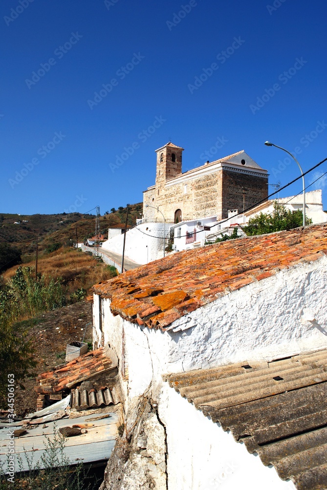 View of the church (Parroquia de la Encarnacion) over the village rooftops, Benaque, Andalusia, Spain.