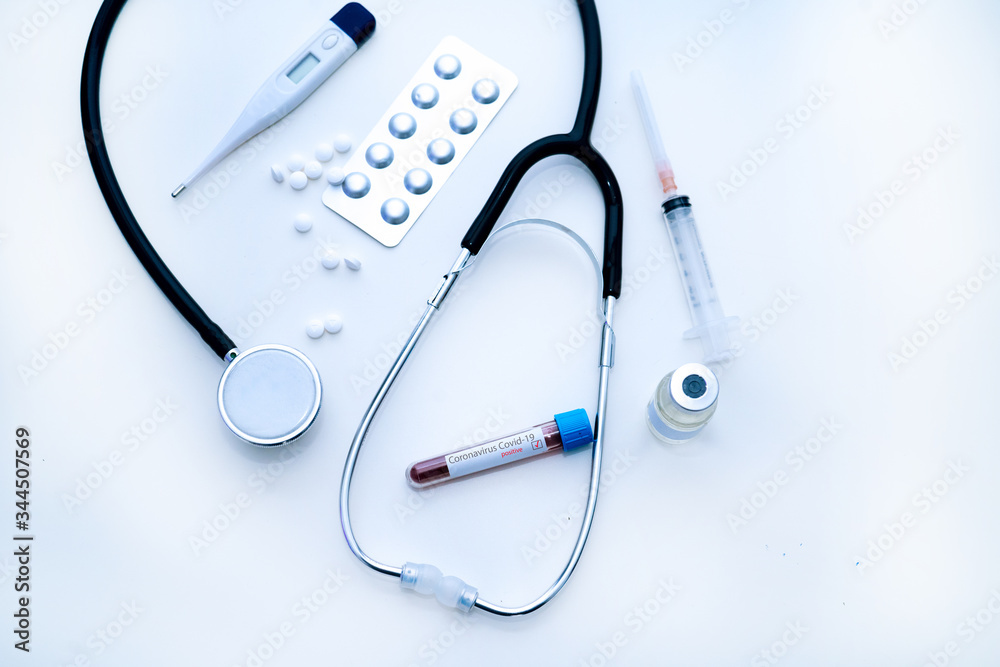 Coronavirus Covid-19 outbreaking. Medicine and epidemic concept. Tube with positive blood test result, protective face mask, medication pills, stethoscope, vial and syringe, vaccine in laboratory. Coronavirus Covid-19 outbreaking. Medicine and epidemic concept. Tube with positive blood test result, protective face mask, medication pills, stethoscope, vial and syringe, vaccine in laboratory.