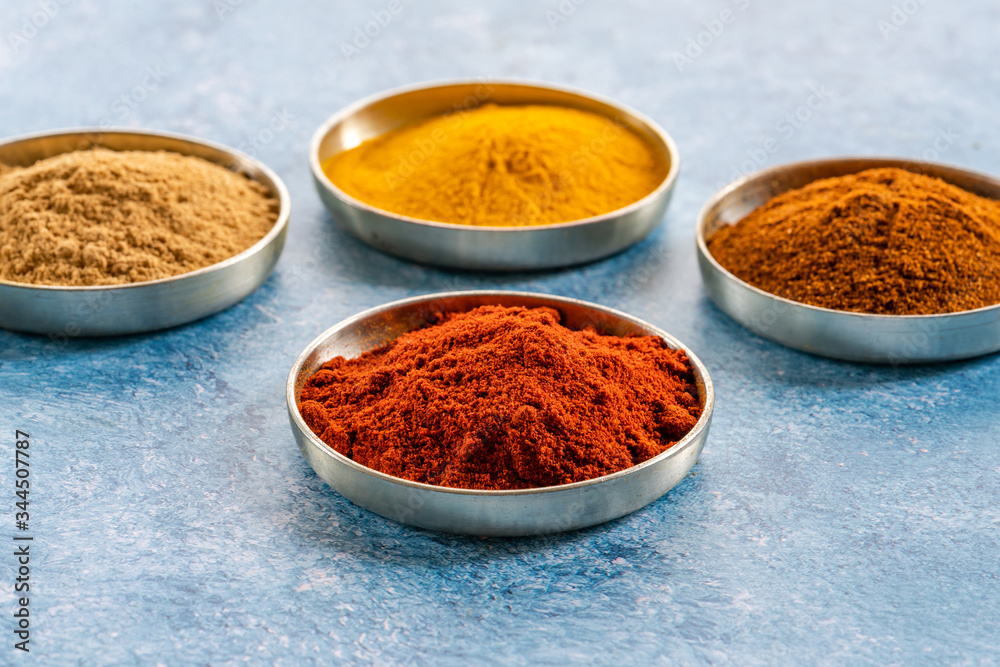 Ground spices in pots - paprika, tumeric, chilli and curry powder - closeup with selective focus Ground spices in pots - paprika, tumeric, chilli and curry powder - closeup with selective focus