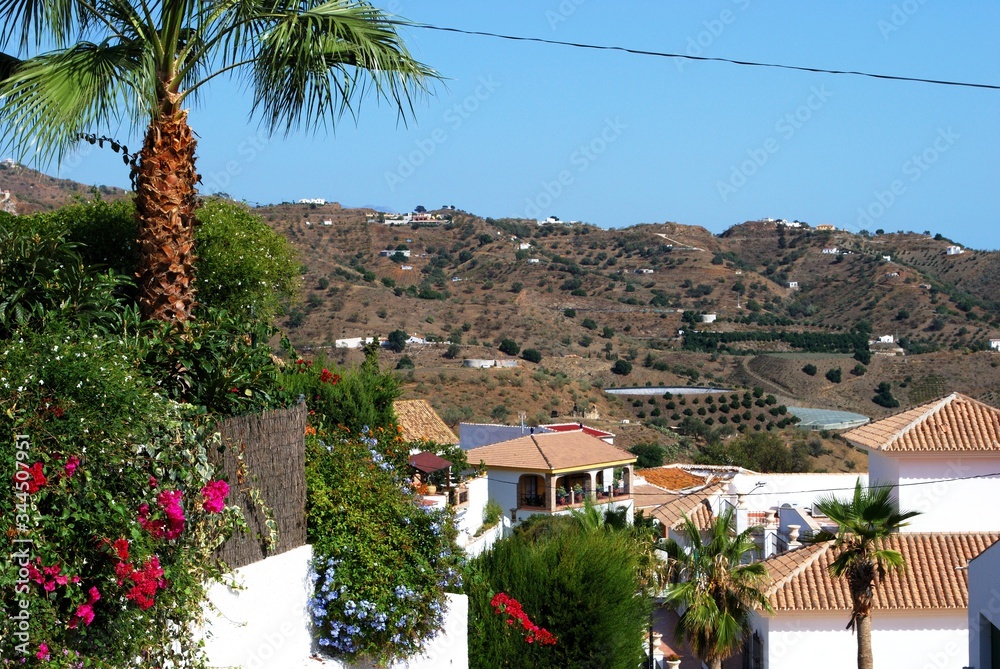 View over village rooftops towards the mountains, Macharaviaya, Andalusia, Spain.