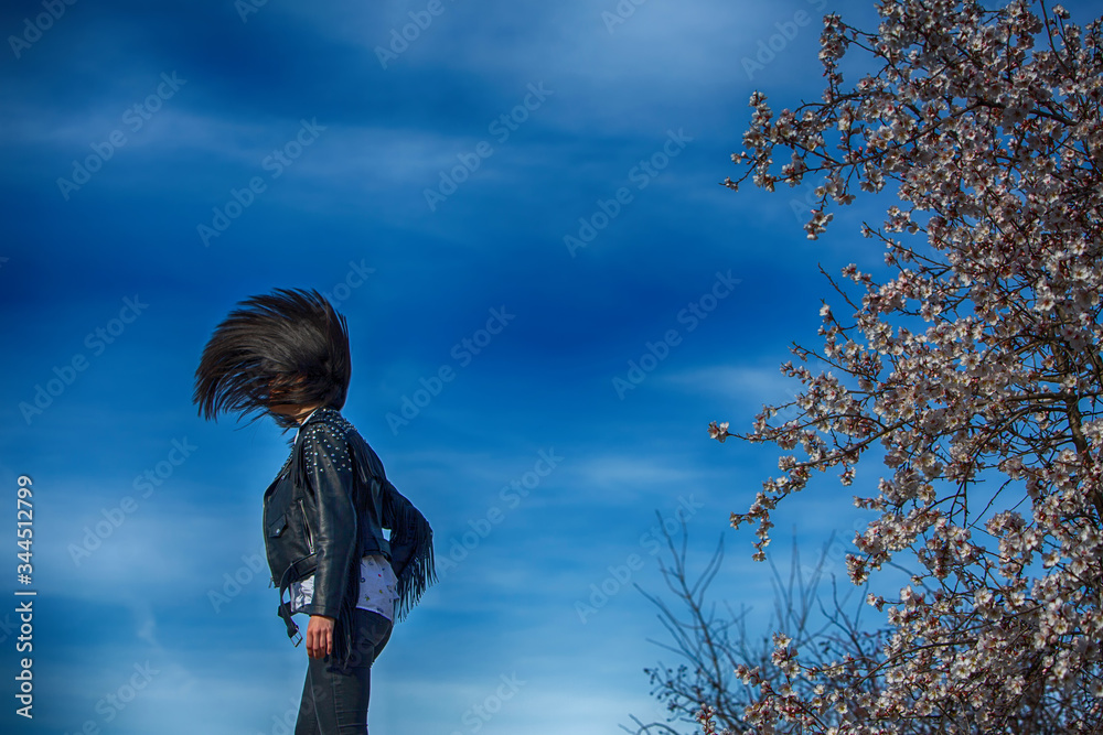 very beautiful young woman moving her hair up and clouds in the background very beautiful young woman moving her hair up and clouds in the background