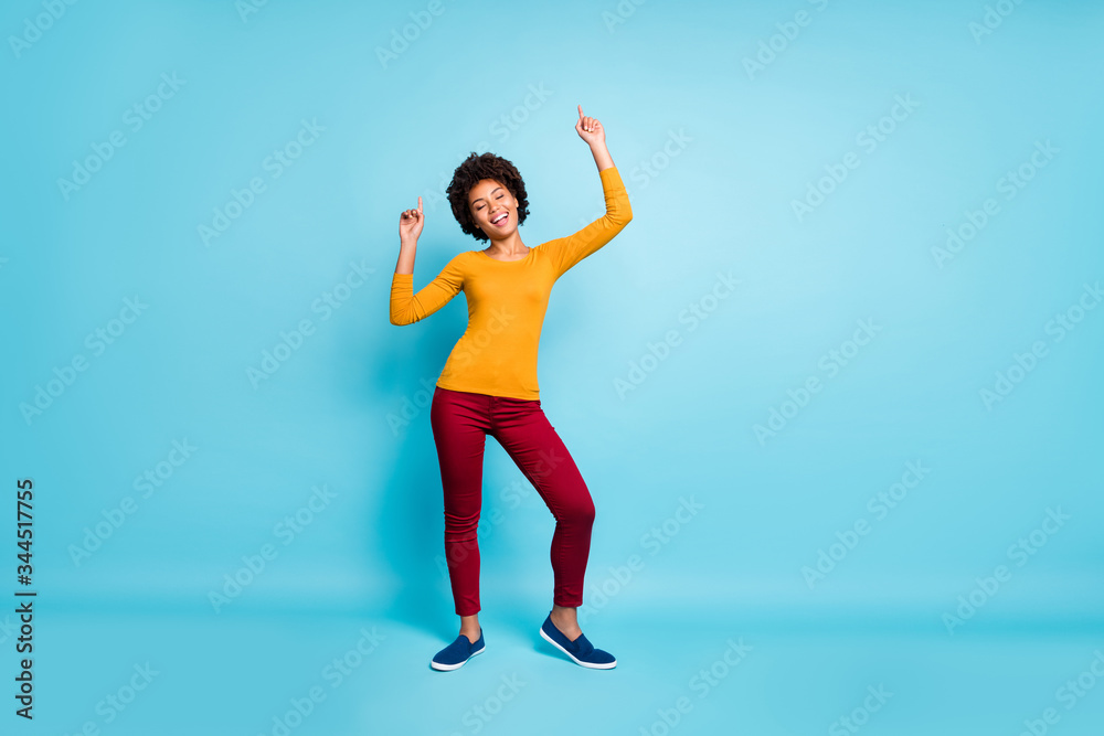 Full size photo of positive cheerful wild cool youth afro american girl dance enjoy rejoice raise index finger close eyes wear good look outfit footwear isolated blue color background Full size photo of positive cheerful wild cool youth afro american girl dance enjoy rejoice raise index finger close eyes wear good look outfit footwear isolated blue color background
