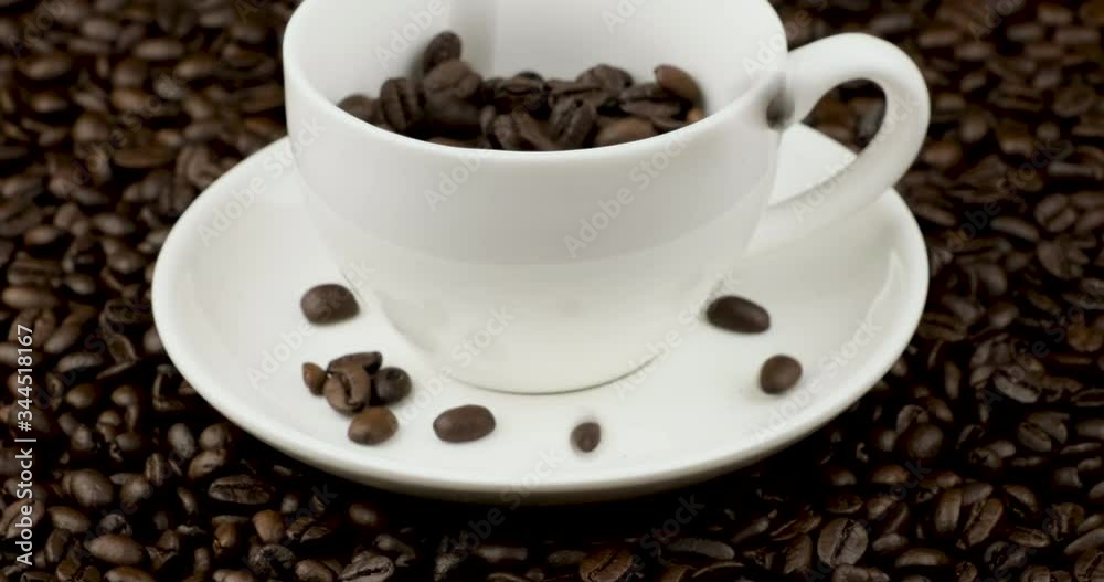 Dolly in shot of blurred motion pouring coffee beans in the white cup on coffee field Dolly in shot of blurred motion pouring coffee beans in the white cup on coffee field