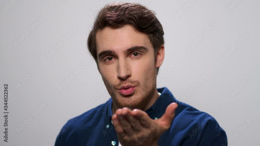 Handsome man sending air kiss to camera. Smiling guy flirting with camera Handsome man sending air kiss to camera. Smiling guy flirting with camera