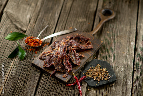 Fototapeta Naklejka Na Ścianę i Meble -  Dried beef meat on wooden board with spices chili pepper leaf cuisine