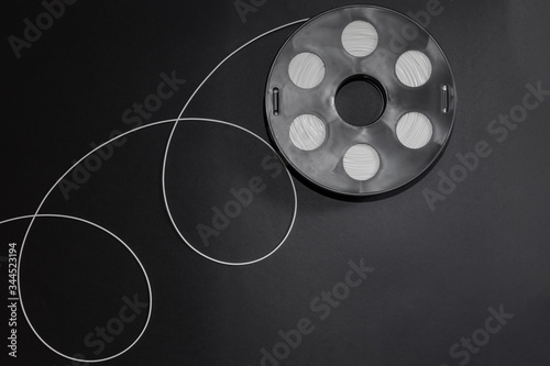 Foto Black coil with white plastic, 3D printing filament reel for 3d printers  and with a geometric pattern of loops are on a black background