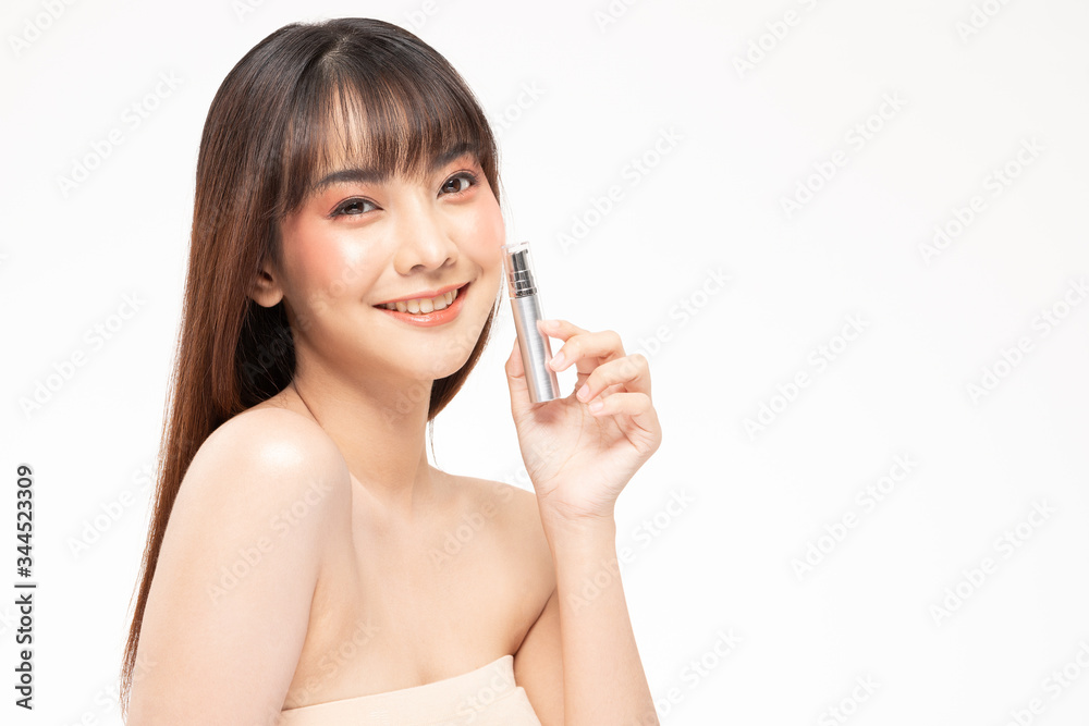 Beauty asian woman brown hair looking smile in camera happiness and hold bottle cosmetic cream lotion and cheerful with make up brush,Beauty Concept on white background. Beauty asian woman brown hair looking smile in camera happiness and hold bottle cosmetic cream lotion and cheerful with make up brush,Beauty Concept on white background.