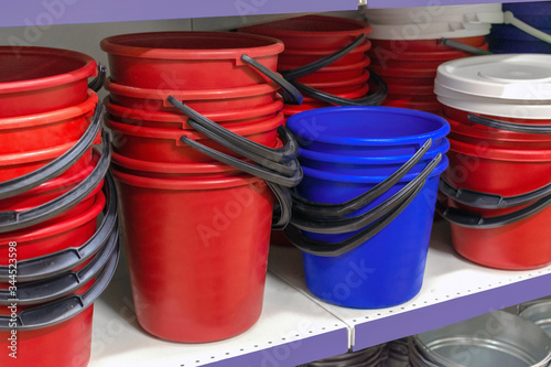  plastic buckets of red and blue on the counter in the store