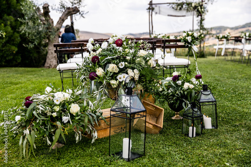 in backyard of villa in Tuscany there is ceremony wooden arch decorated with eucalyptus compositions and flowers