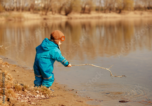Cute child playing on the river in the open air. Active lifestyle