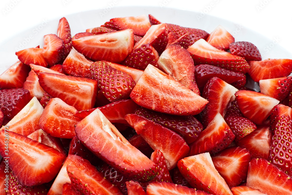 Red strawberry slices in a white bowl, isolated on white background Red strawberry slices in a white bowl, isolated on white background