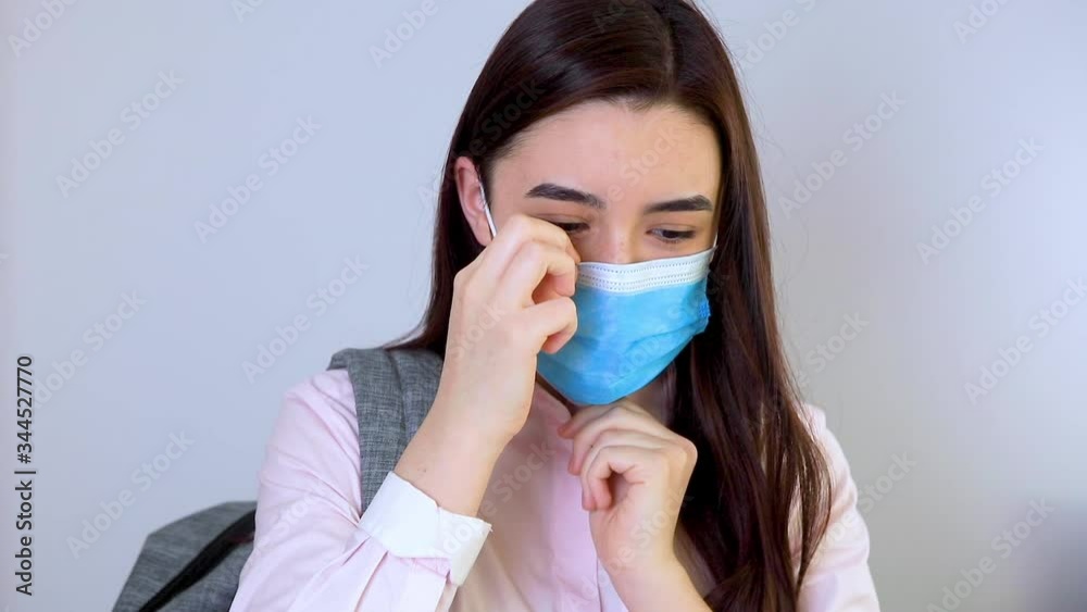 High school girl with backpack putting mask on her face. Student girl ready for back to school during the coronavirus pandemic. High school girl with backpack putting mask on her face. Student girl ready for back to school during the coronavirus pandemic.