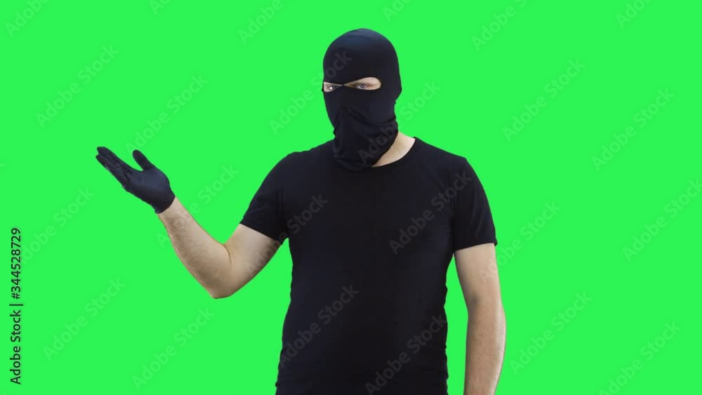 A man in a balaclava offers to make a choice,green screen background A man in a balaclava offers to make a choice,green screen background