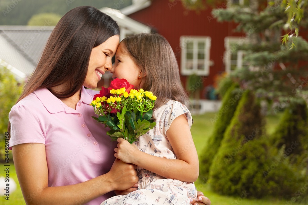Mother and daughter with a bouquet of flowers on the outdoor background. Mother and daughter with a bouquet of flowers on the outdoor background.
