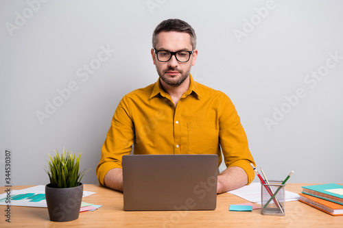 Portrait of focused concetrated intelligent man work home use laptop have online communication with partners colleagues wear yellow shirt isolated over gray color background photo