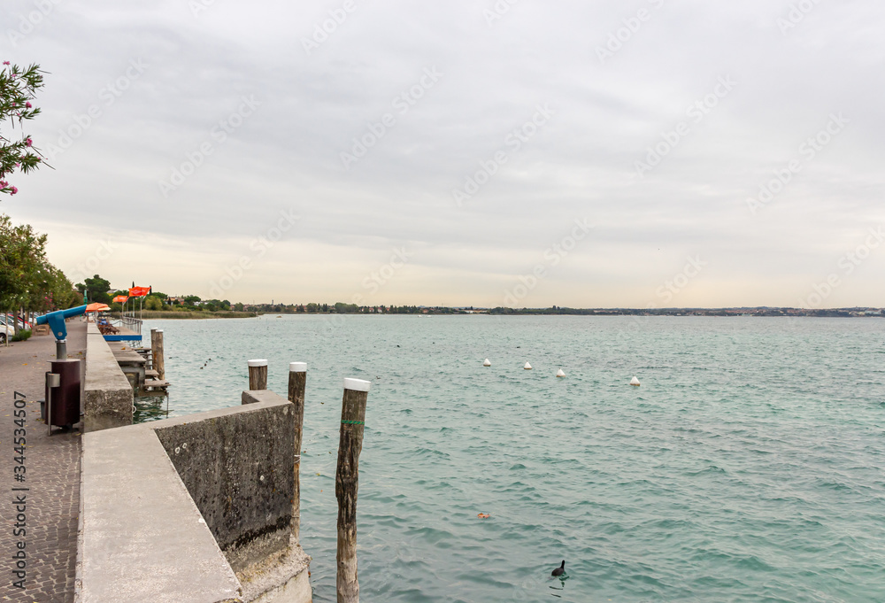 Fototapeta premium View of Lake Garda from the promenade of the Sirmione town in Lombardy, northern Italy