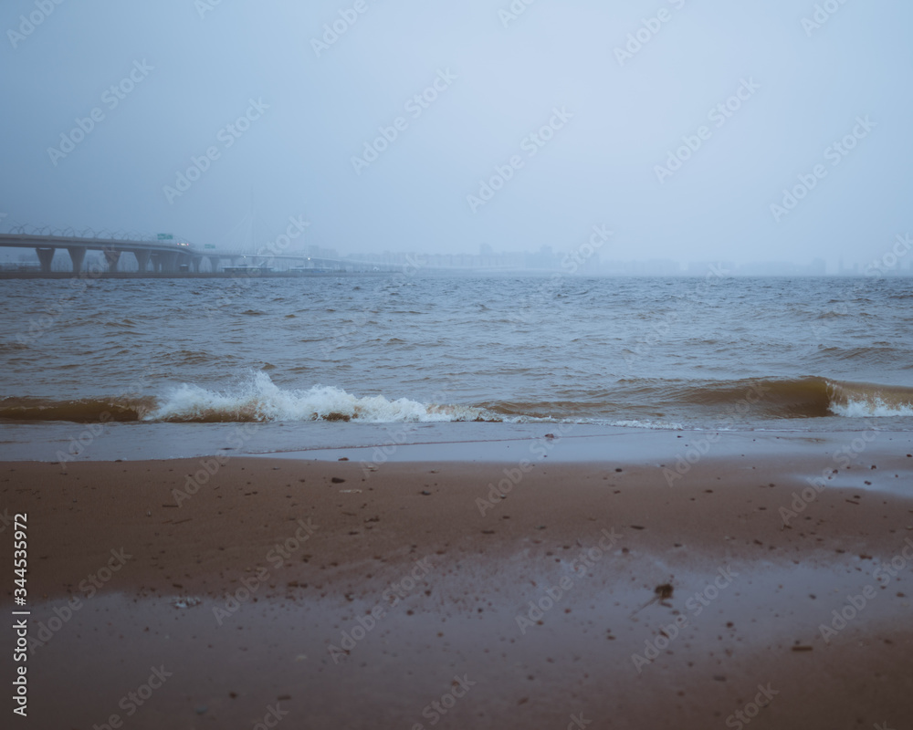 beach in the morning with fog and bridge