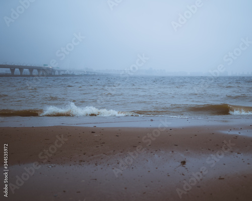 beach in the morning with fog and bridge