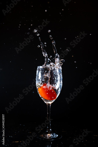 Cherry tomato splash water.  Cherry tomato pouring into glass.
