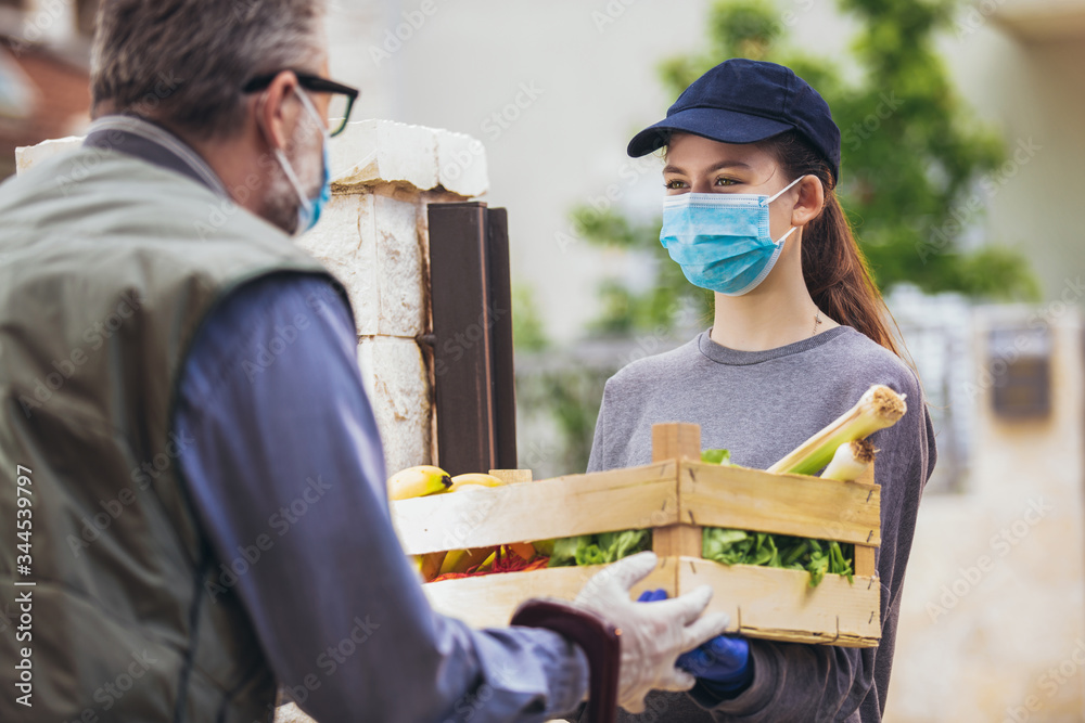 Teenage girl is delivering some groceries to an elderly person, during the epidemic coronovirus, COVID-19. Teenage girl is delivering some groceries to an elderly person, during the epidemic coronovirus, COVID-19.