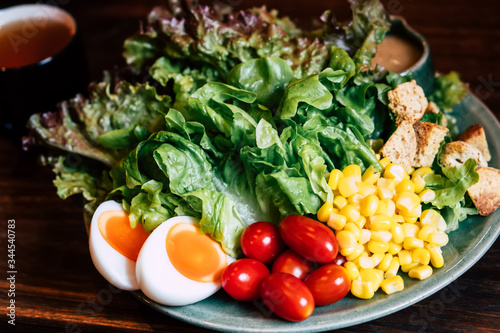 Homemade delicious fresh organic local farm salad for breakfast lunch healthy nutrition light meal with vegetables egg  letture  cherry tomato  corn vegetarian recipe serve on wooden table background