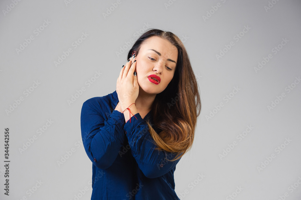 Young caucasian woman suffers from ear pain, feels sick, ill and weakness isolted on gray studio background. Symptoms of desease or unhealthy lifestyle. Sickness, ilness, sad and upset. Copyspace. Young caucasian woman suffers from ear pain, feels sick, ill and weakness isolted on gray studio background. Symptoms of desease or unhealthy lifestyle. Sickness, ilness, sad and upset. Copyspace.