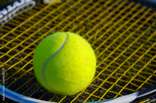 Ball for tennis on the background of racket strings. © Andrew