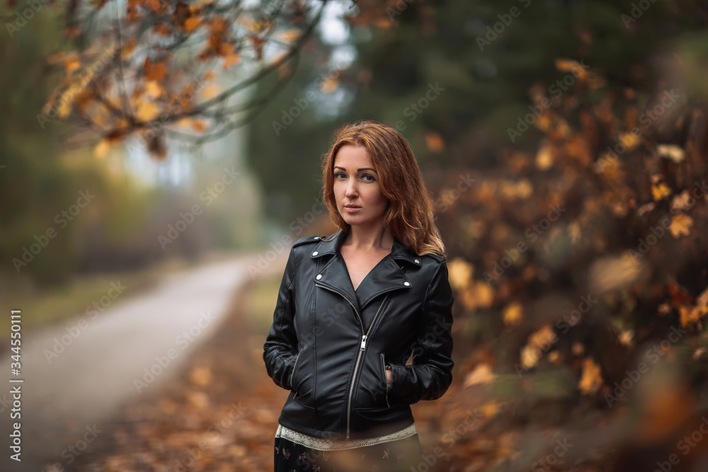 Fabulous redhead dreamy woman with long curly hair on blurred autumn background. Girl on fabulous background of park with orange autumn leaves. Fabulous redhead dreamy woman with long curly hair on blurred autumn background. Girl on fabulous background of park with orange autumn leaves.