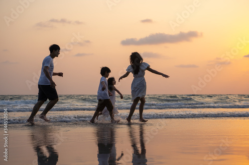 Asian Family walking and playing at beach sunset with kids happy vacation concept