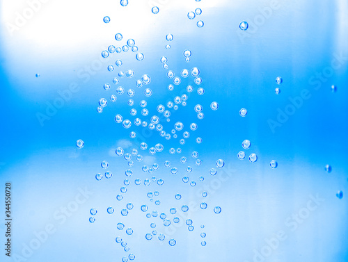 Close-up water drops in water bottle against to blue background