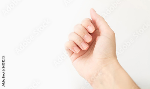 Close up woman hand with nails form of soft square holds something in fingers. Female keeps virtual object. Nail care at home. Copy space.