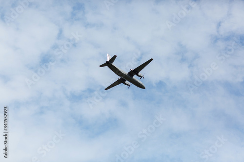 A beautiful view of a flying passenger wide-body airliner, an airplane, against a background of white clouds in a blue summer sky. selective focus