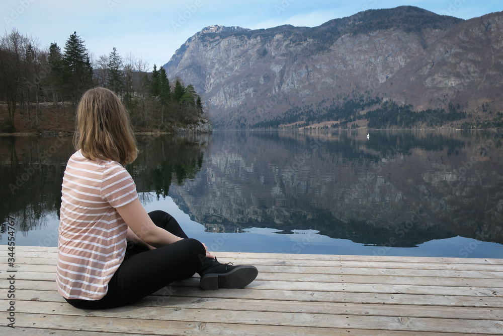 Fototapeta premium young woman sitting on a pier