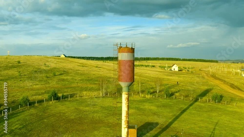 Old rusty water tower in village photo