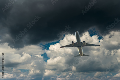 Commercial airplane flying through clouds in dramatic sky. Travel concept