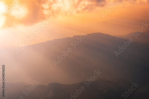 Sunrise above misty mountains from airplane window. Natural background. © thayra83