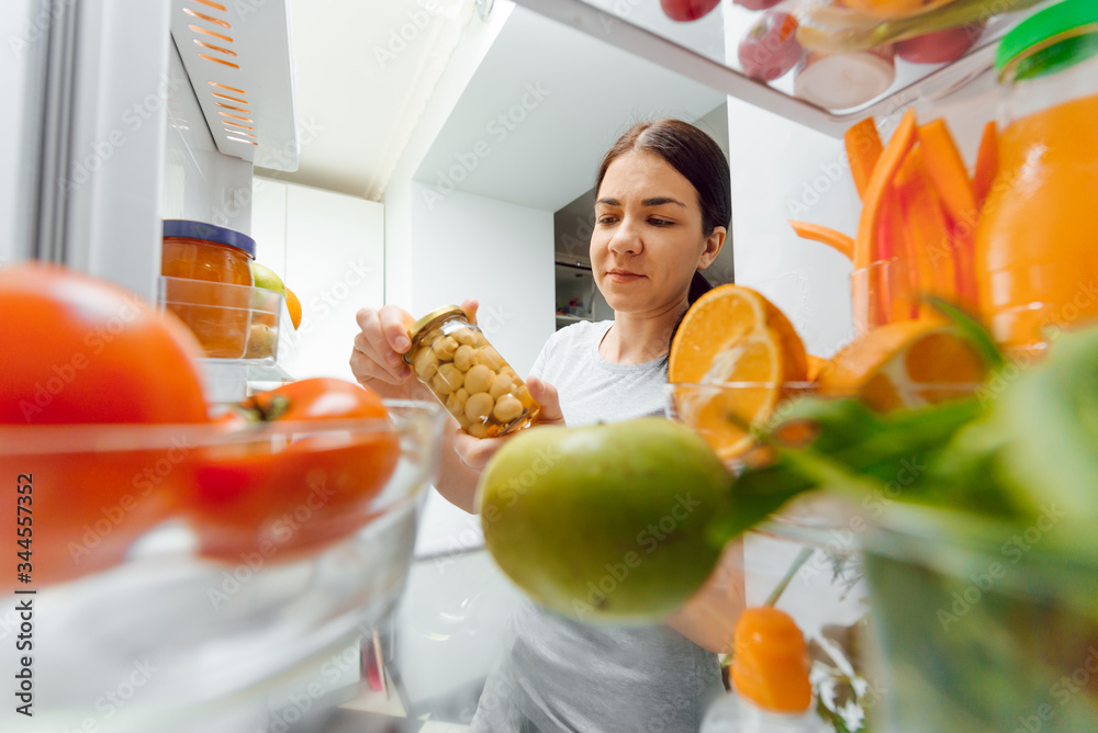 Happy Woman With Vegetables In Front Of Open Refrigerator. concept of healthy eating at home