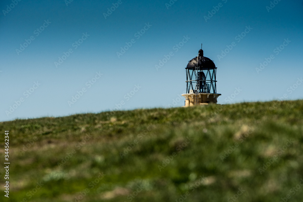 dalla collina spunta un faro con il cielo di sfondo dalla collina spunta un faro con il cielo di sfondo