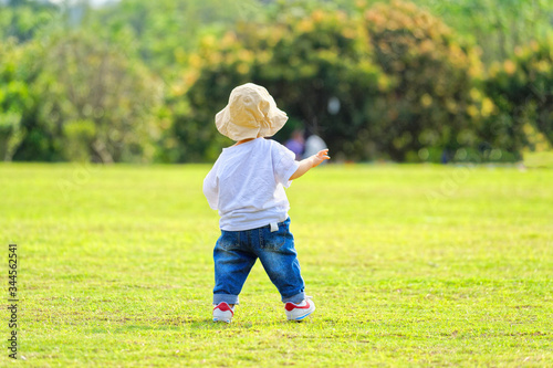 The little boy in a hat in the outdoor lawn
