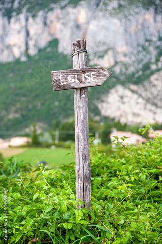 Wooden sign indicating the direction of the church in a village in France