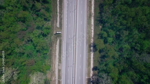 The scenic road passes through dense forest. Drone shooting cars on the road