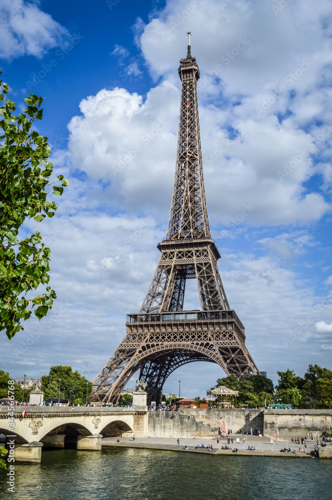 View of the Eiffel Tower with Seine River and bridge in summer, Paris, France.