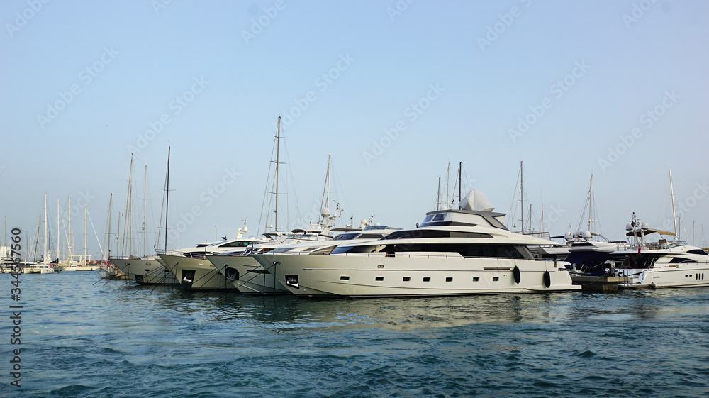 white yachts with masts in the sea on the pier, summer evening in europe , luxury lifestyle white yachts with masts in the sea on the pier, summer evening in europe , luxury lifestyle
