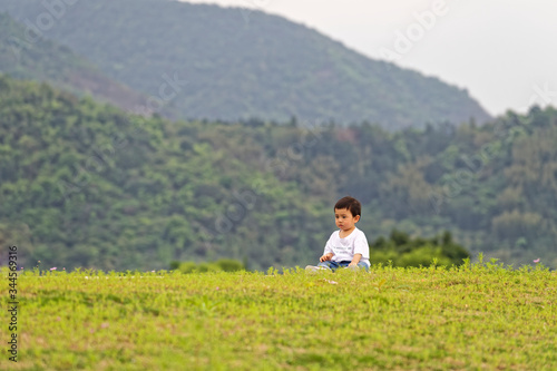 A little boy sitting on the grass © zirong