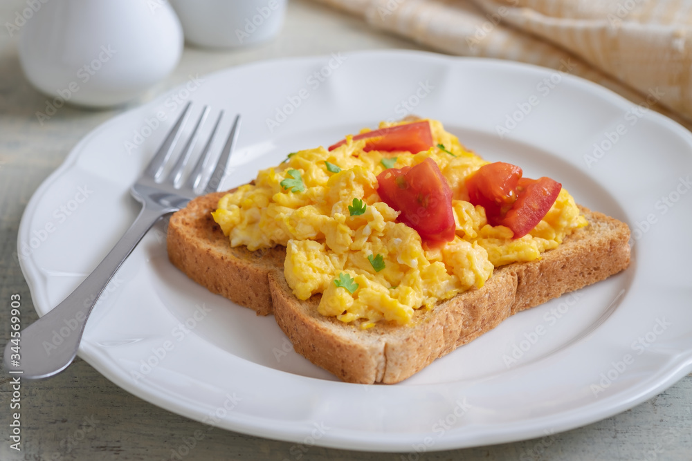 Scrambled eggs with tomato on toasted whole wheat bread Scrambled eggs with tomato on toasted whole wheat bread