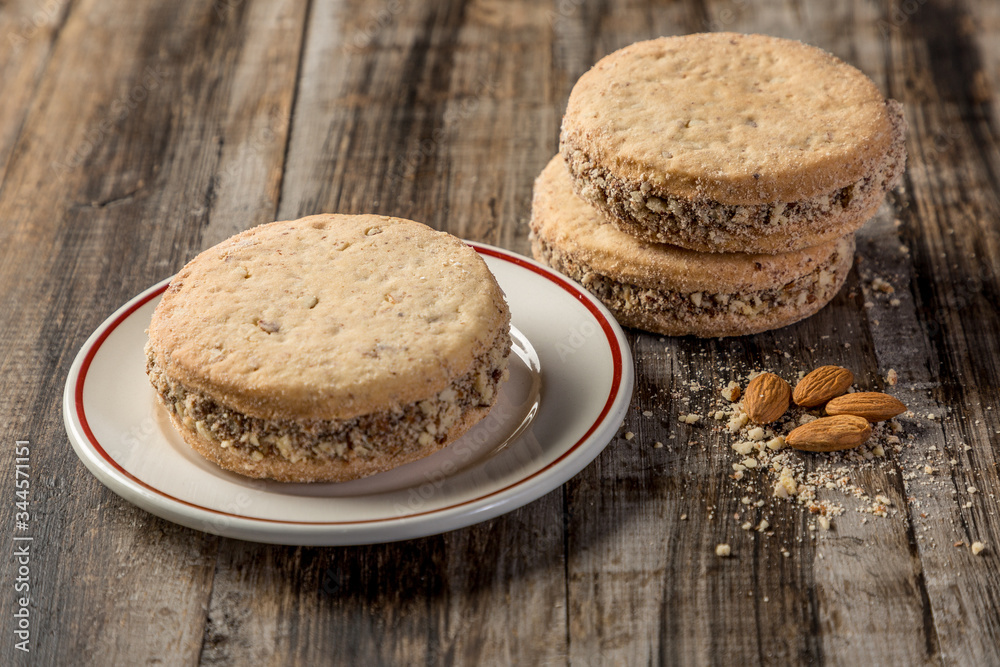 cornstarch alfajor with dulce de leche and homemade coconut in squares on wood