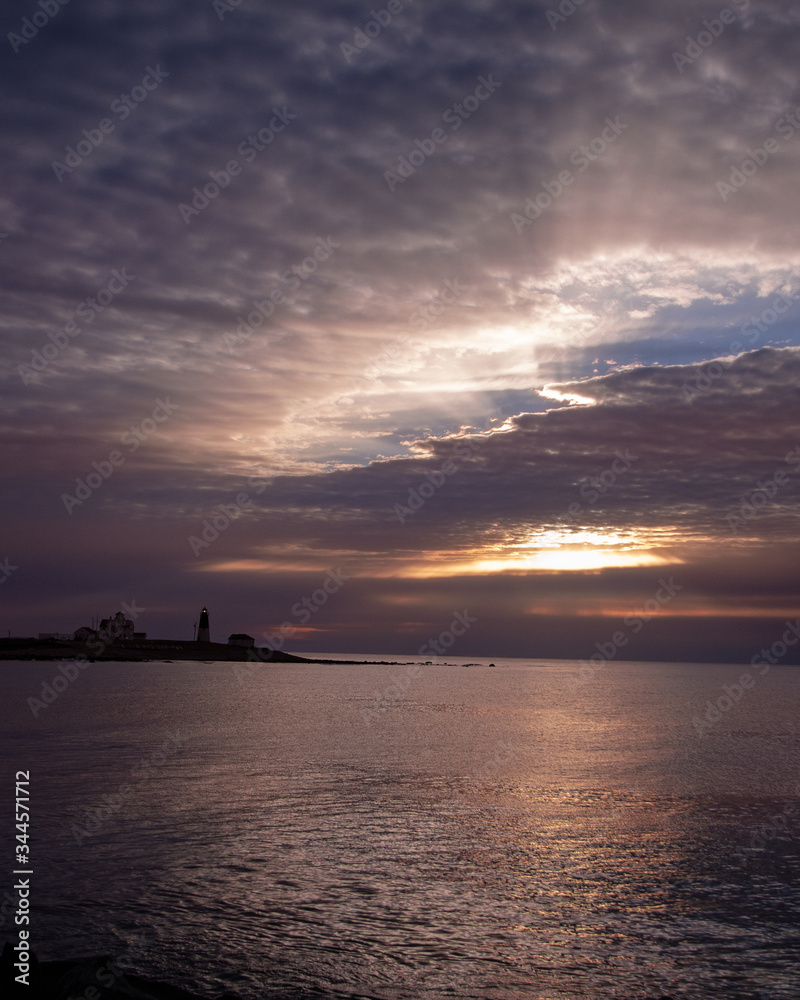 sunrise through the clouds with lighthouse sunrise through the clouds with lighthouse