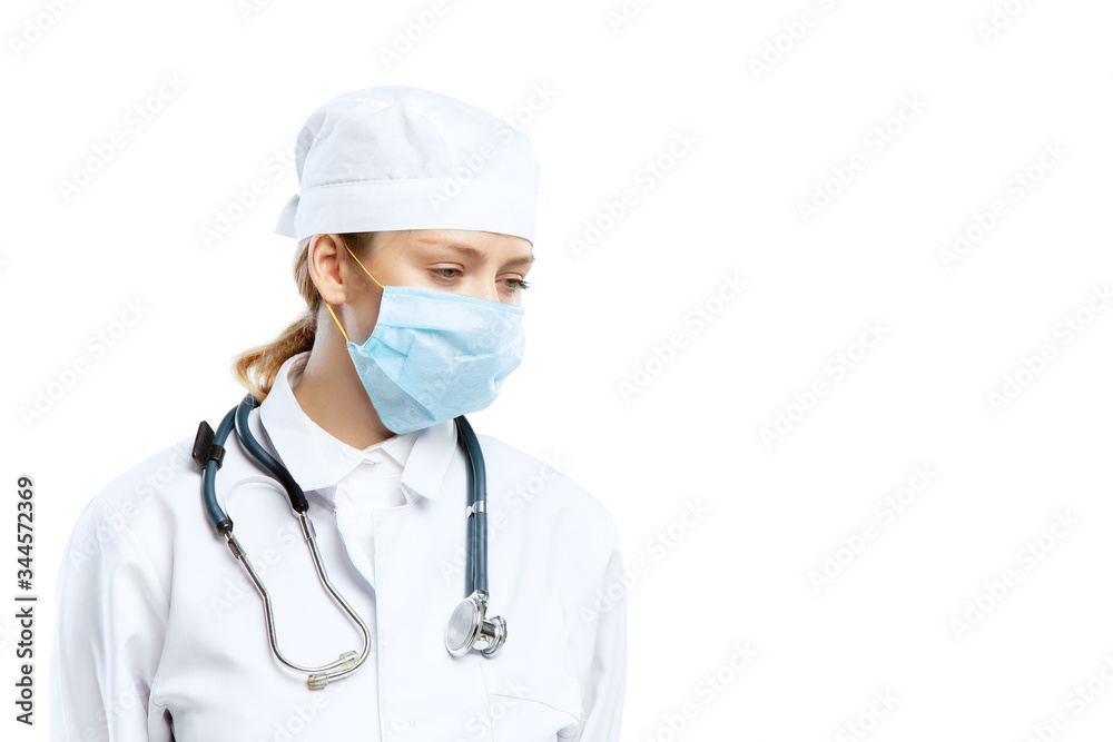 Tired, despair. Female young doctor with stethoscope and face mask on white studio background. Looks sad, serious. Concept of healthcare and medicine, coronavirus pandemic, danger epidemic, COVID. Tired, despair. Female young doctor with stethoscope and face mask on white studio background. Looks sad, serious. Concept of healthcare and medicine, coronavirus pandemic, danger epidemic, COVID.
